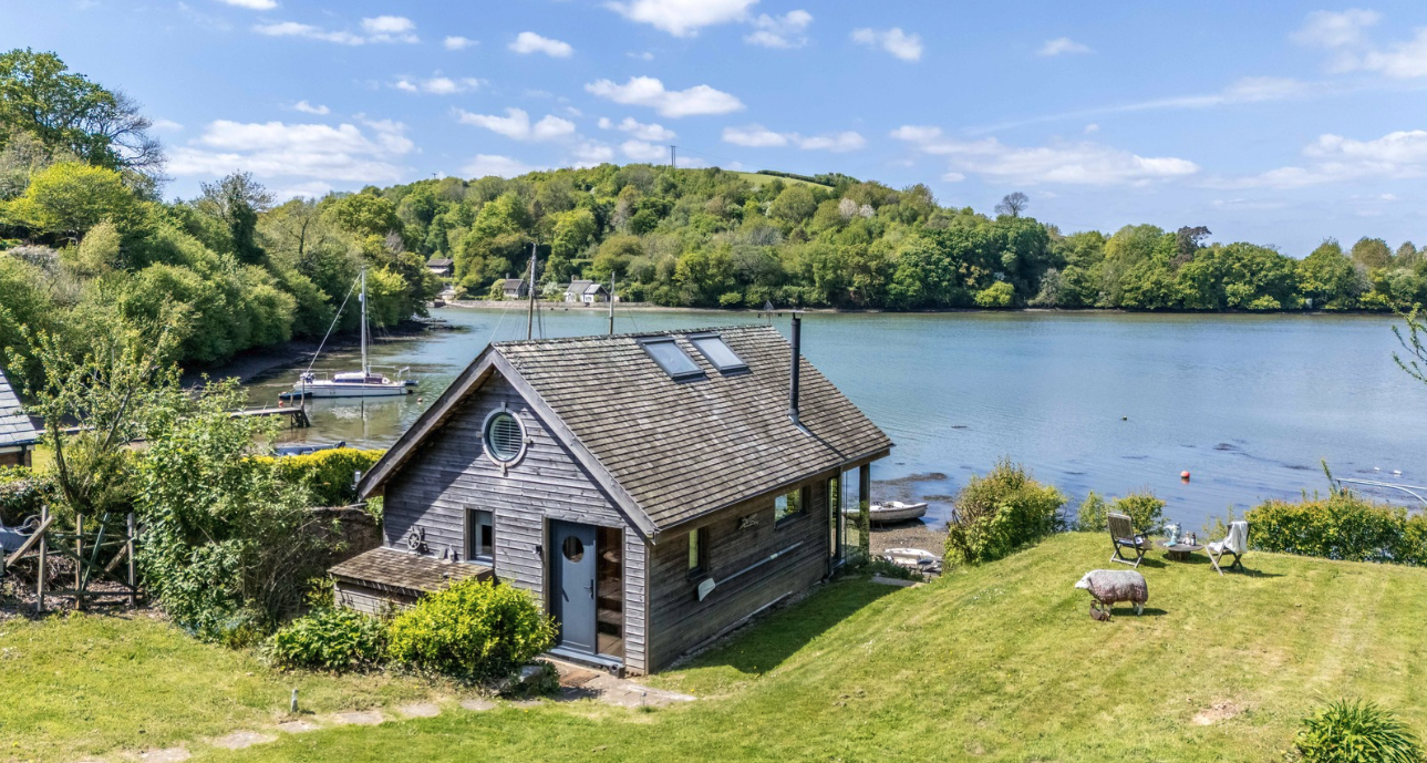 Luxury waterside boathouse with private deck overlooking the river, Fresh Escapes property.