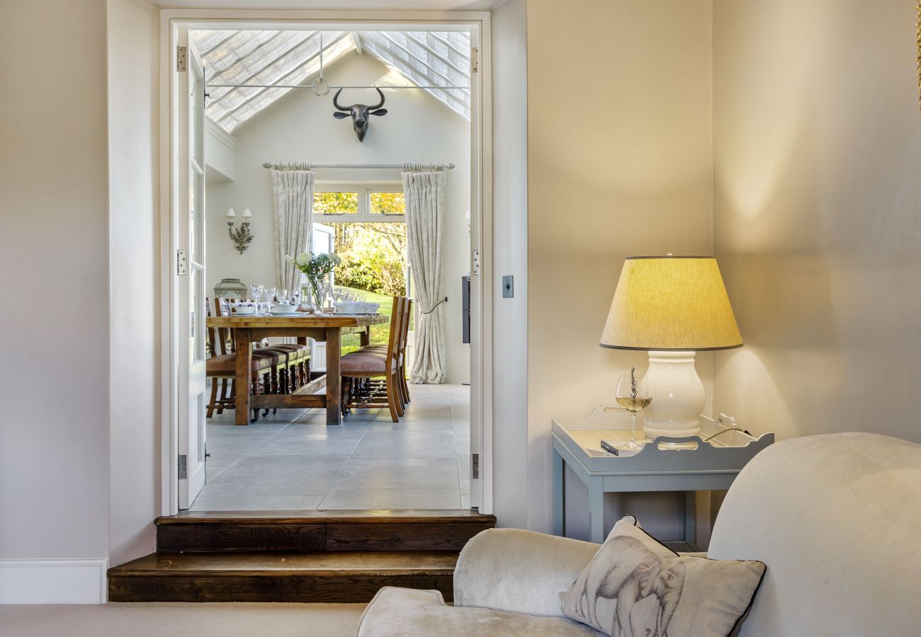 Entry to dining table in airy conservatory