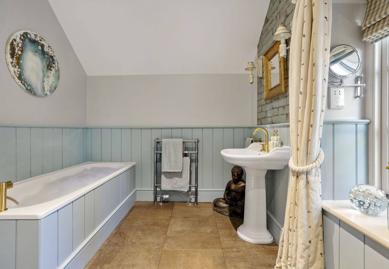 Bathroom with gold mirror and tiled walls