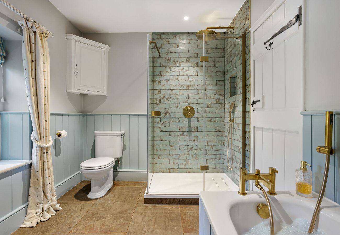 Bathroom with gold mirror and tiled walls