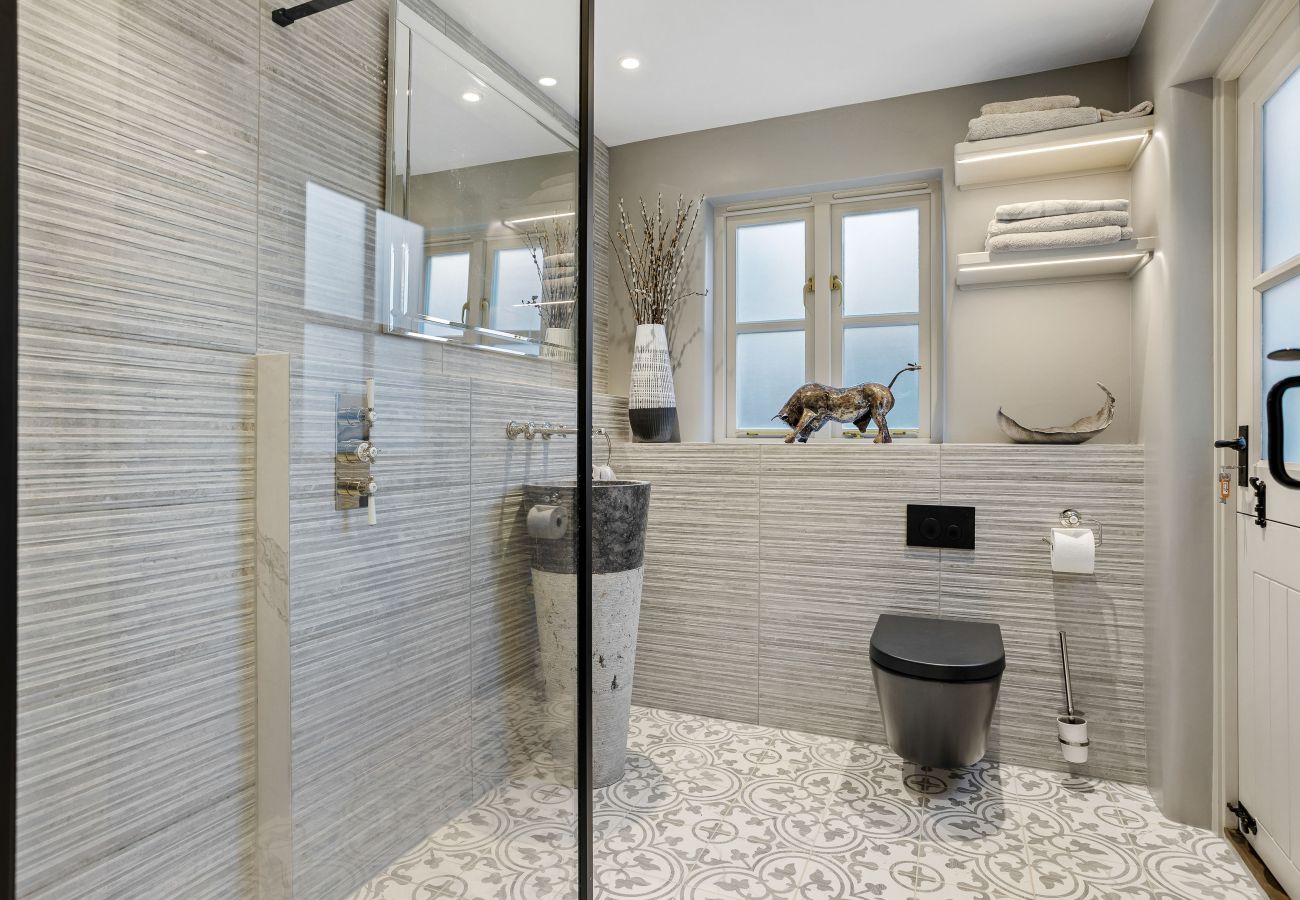 Glass shower and tiled bathroom area