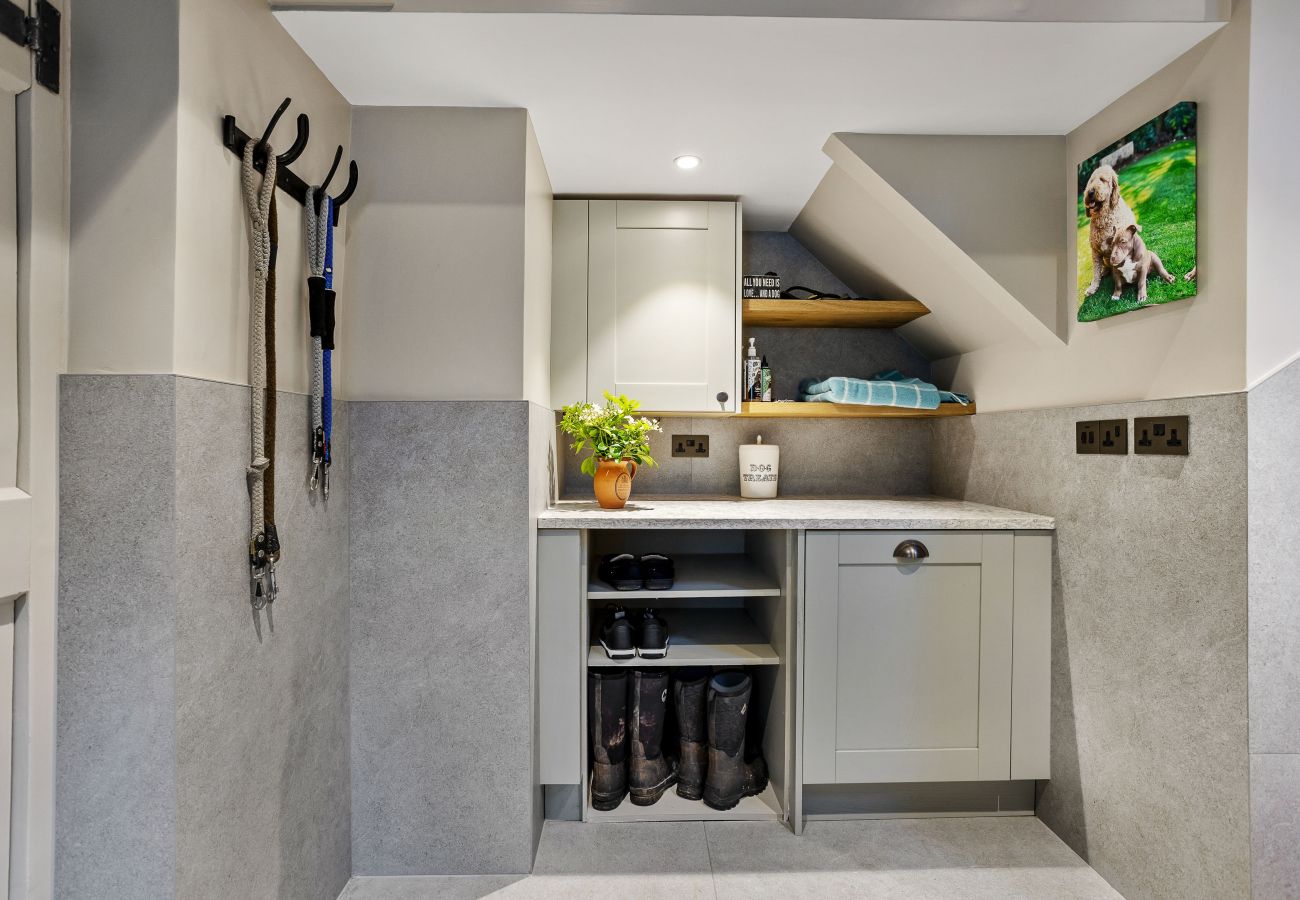 Boot room/utility room with grey marble walls.