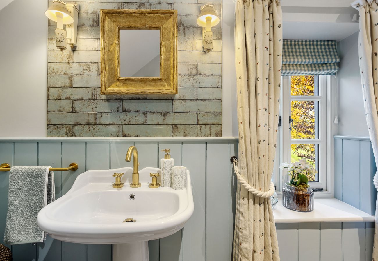 Bathroom with gold mirror and tiled walls