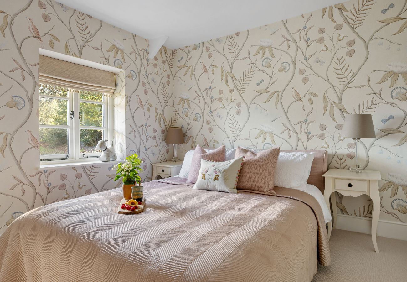 Double bed against floral wallpaper