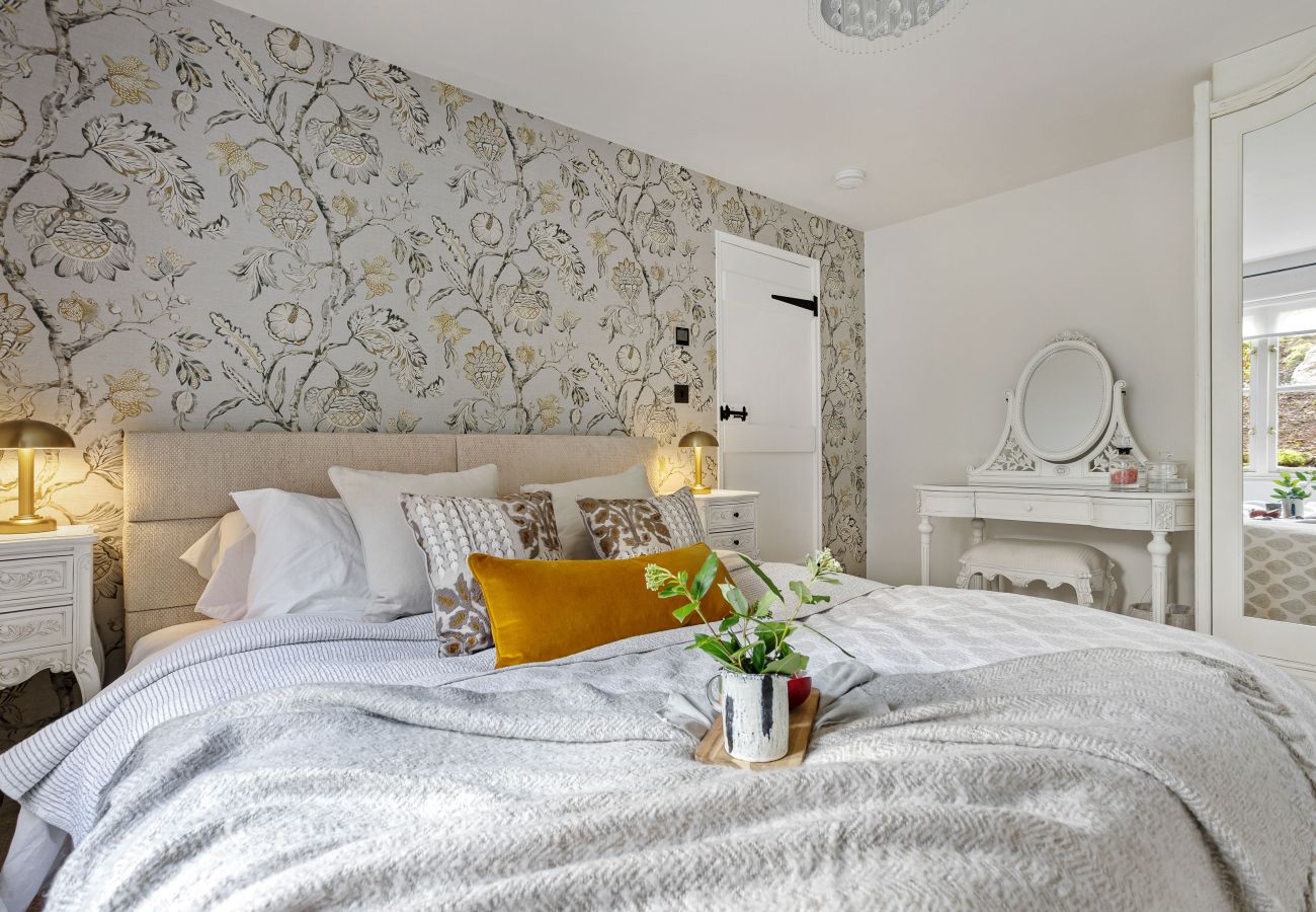 Bed against floral wallpaper wall