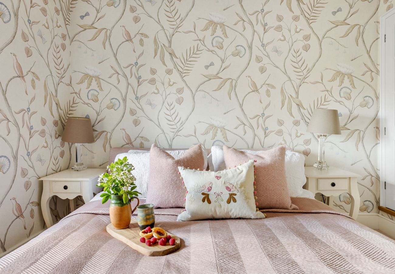 Double bed against floral wallpaper
