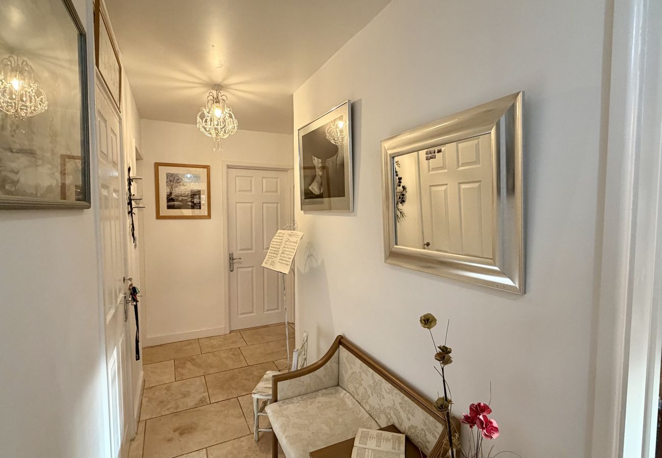 Interior hallway with artwork leading to bedrooms at Pheasants Haunt family holiday home in Devon