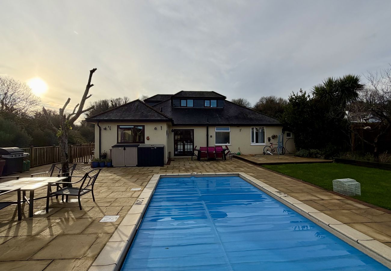 Private outdoor swimming pool with garden and seating at Pheasants Haunt holiday home in South Devon