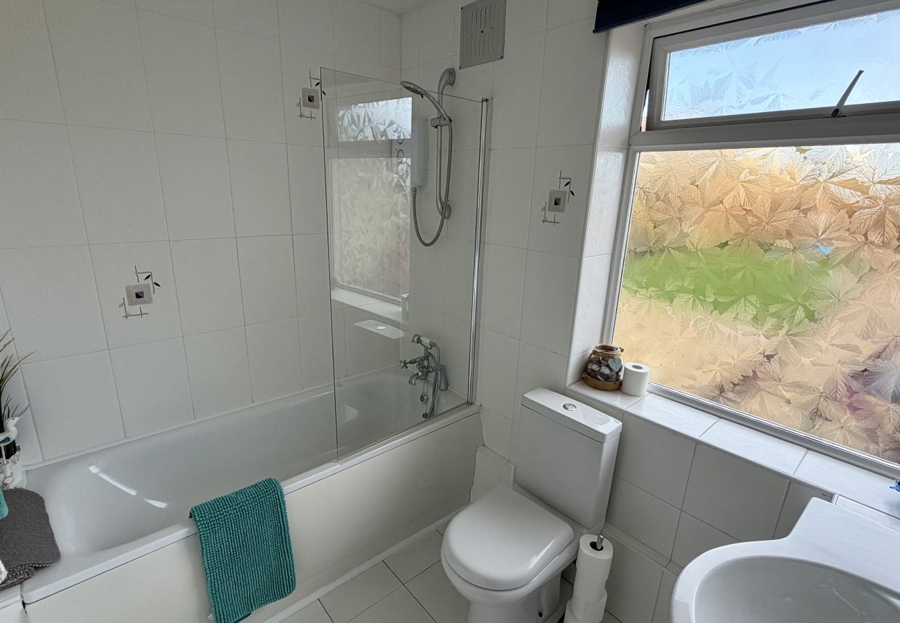 Modern bathroom with bath, shower and heated towel rail at Pheasants Haunt holiday home in Devon