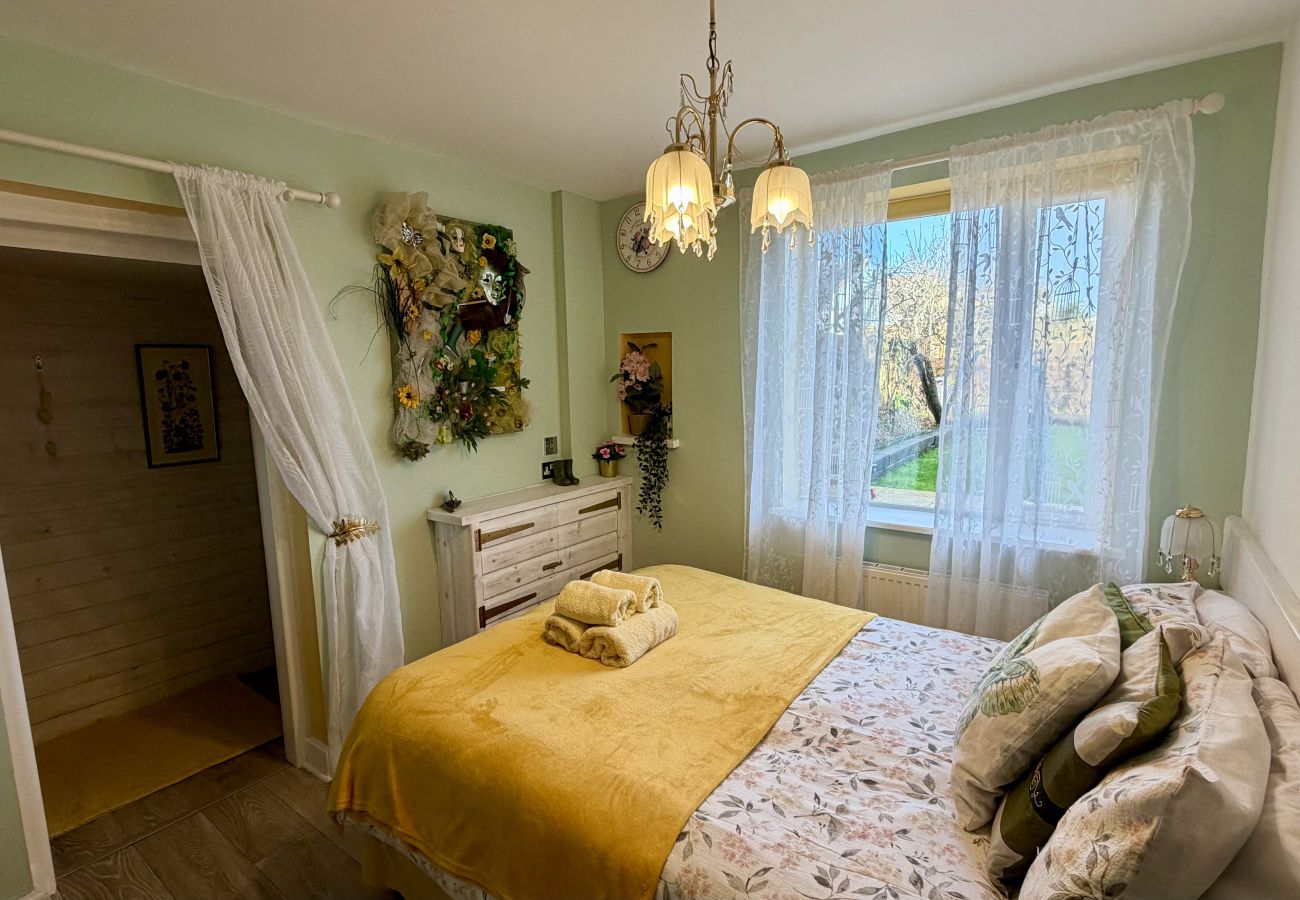 Double bedroom with soft green décor and garden views at Pheasants Haunt holiday home in South Devon