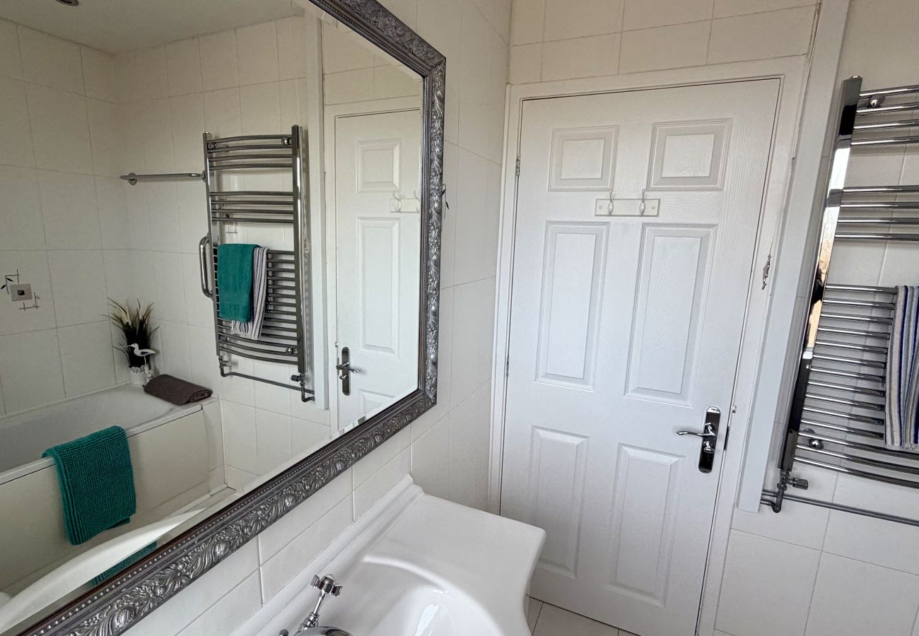 Bathroom vanity and mirror with heated towel rail at Pheasants Haunt family holiday home
