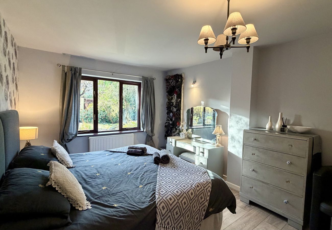 Comfortable bedroom with double bed and garden views at Pheasants Haunt holiday home in Devon