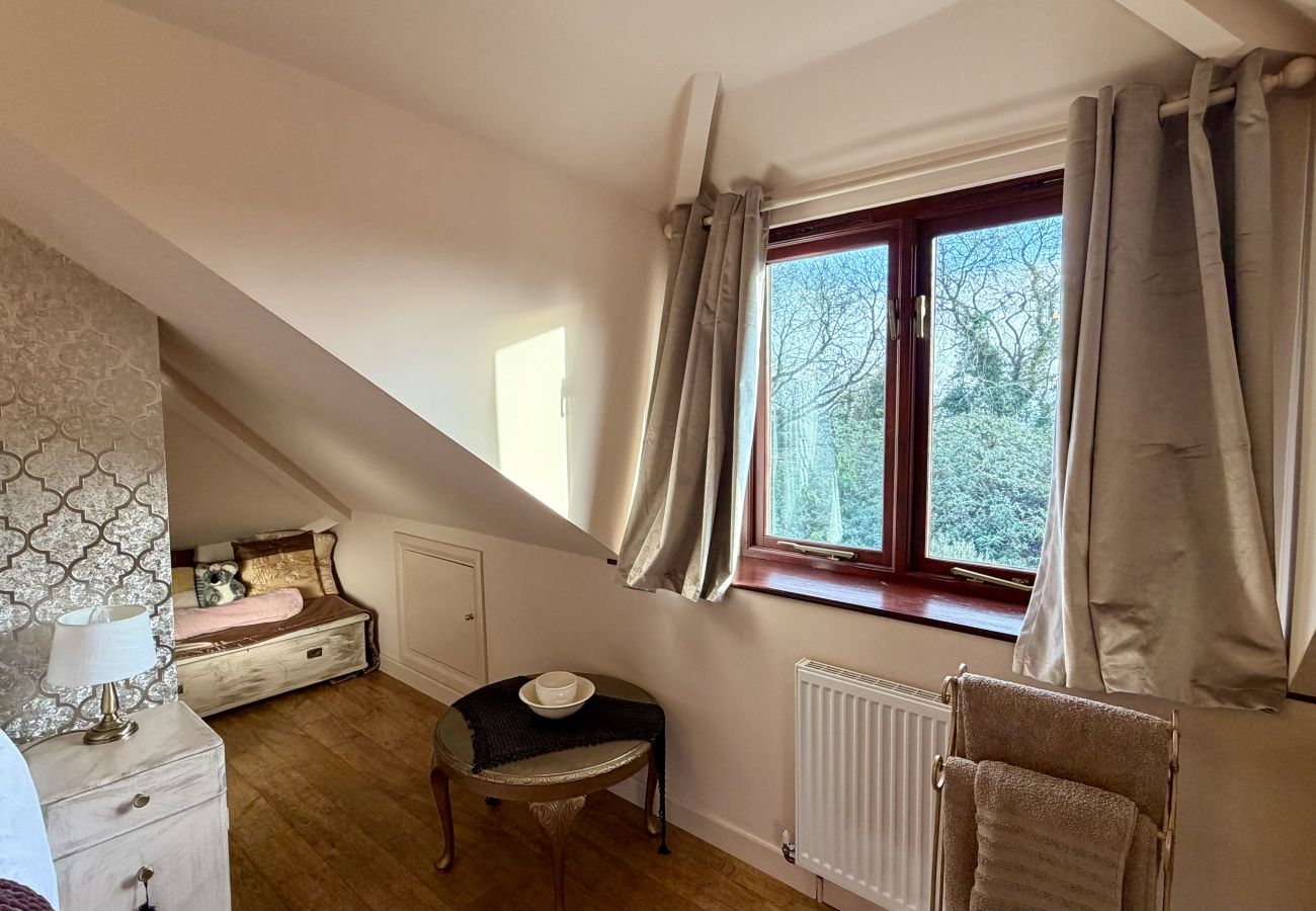 Loft bedroom with window views and soft furnishings at Pheasants Haunt holiday let in Devon