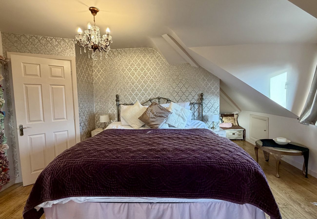 King-size bed in loft bedroom at Pheasants Haunt holiday home on the English Riviera