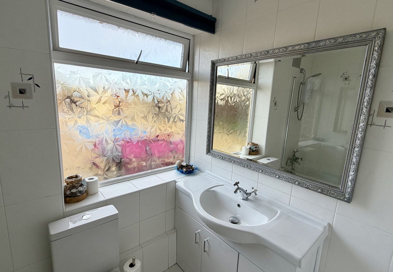 Family bathroom with bath, window and vanity unit at Pheasants Haunt in Paignton
