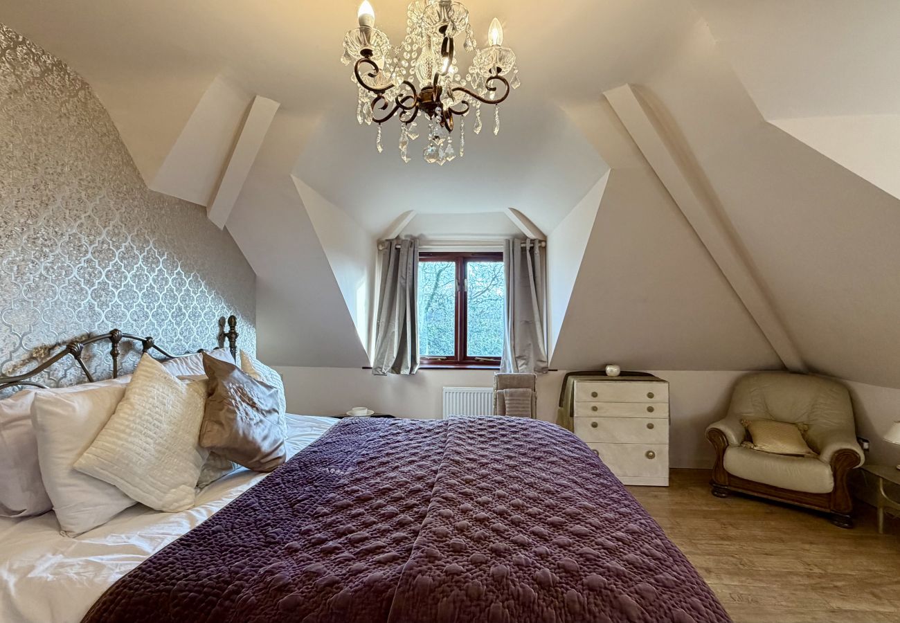 Loft bedroom with window views and soft furnishings at Pheasants Haunt holiday let in Devon