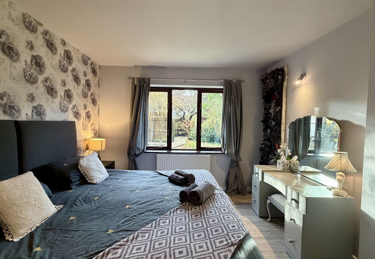 Double bedroom with patterned feature wall and garden views at Pheasants Haunt in Paignton
