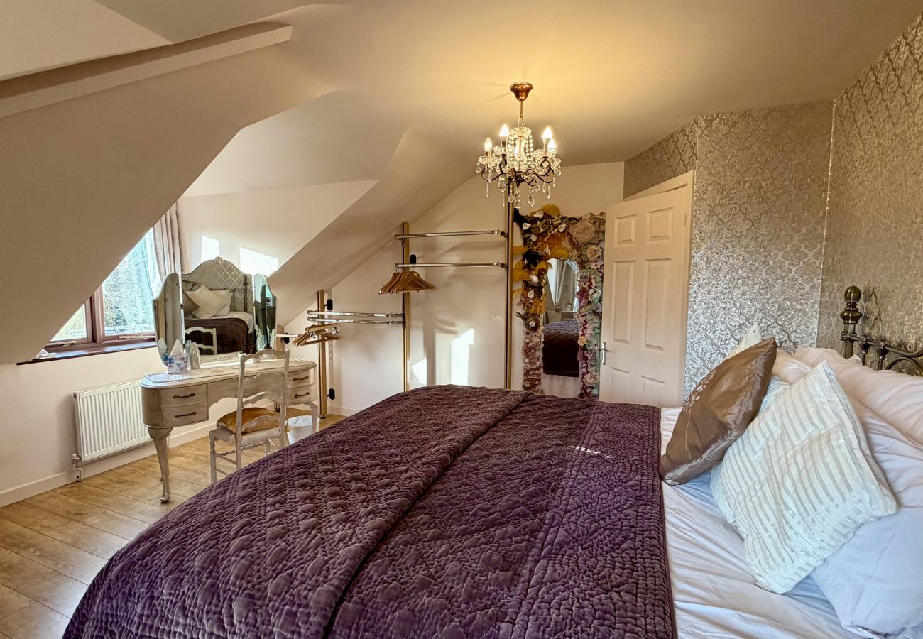 Spacious loft bedroom with sloping ceilings at Pheasants Haunt large holiday home in Devon