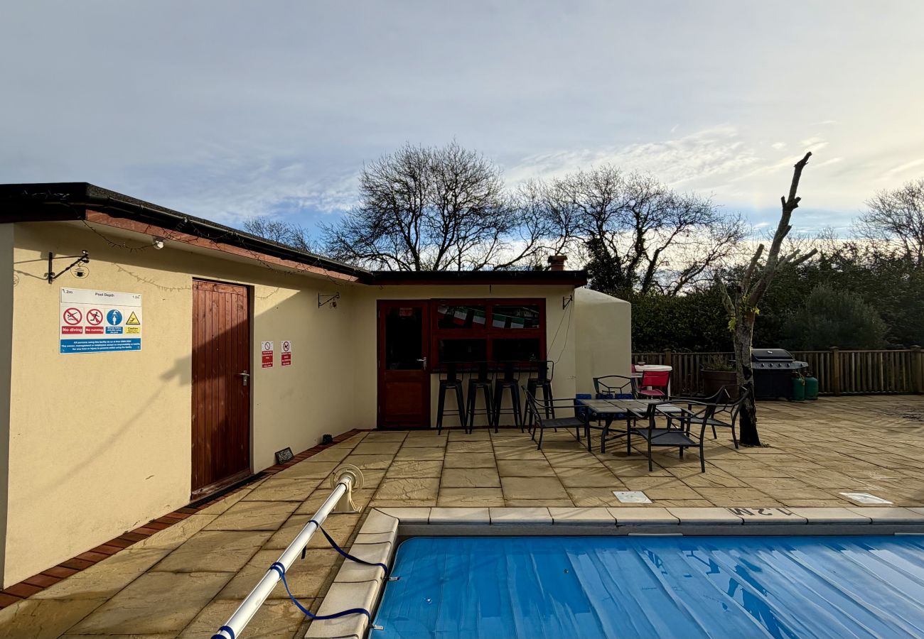 Poolside patio with seating beside private swimming pool at Pheasants Haunt