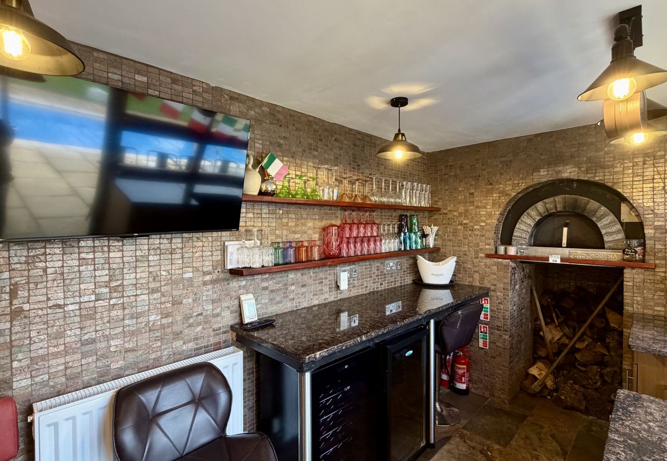 Covered outdoor bar seating area beside the pool at Pheasants Haunt